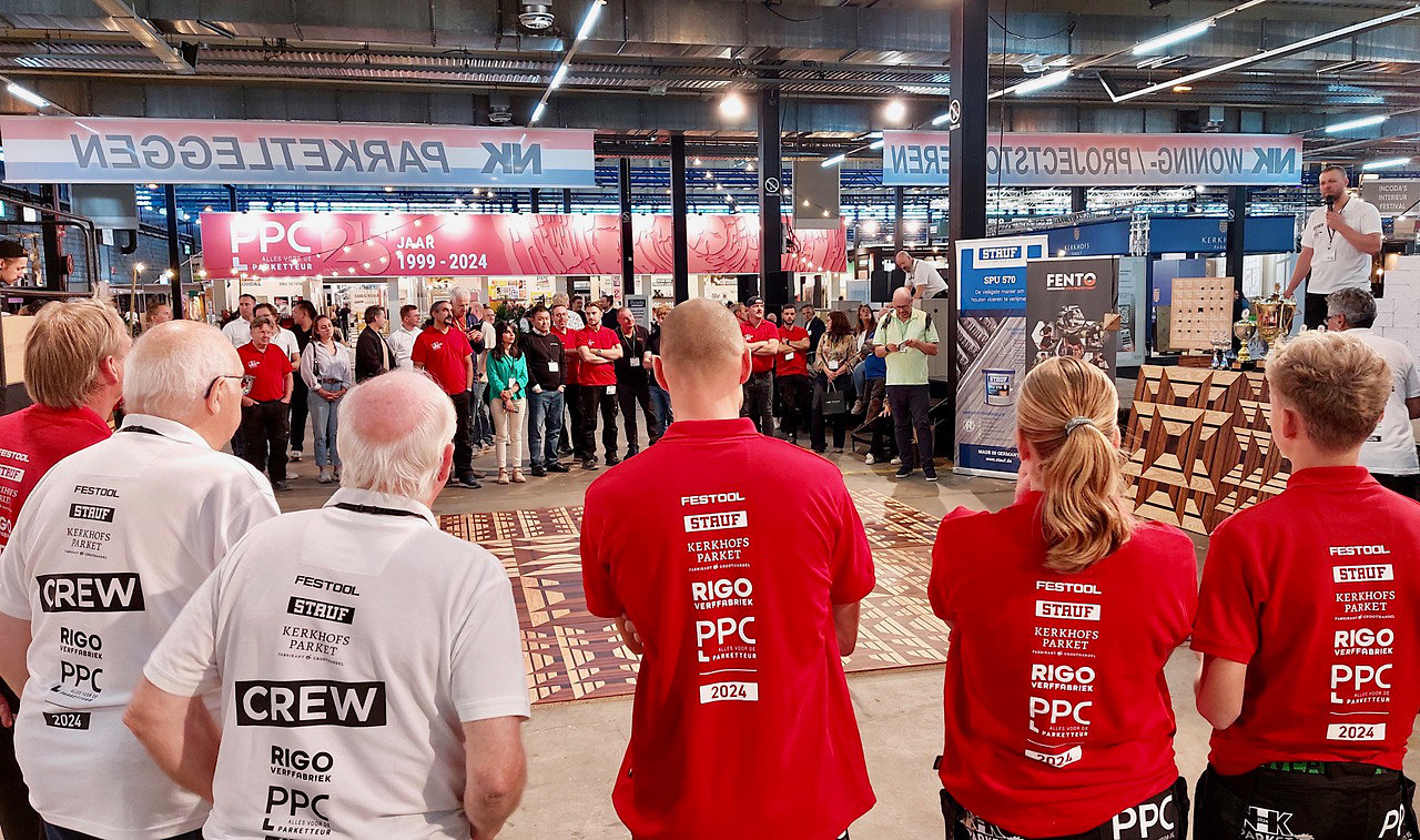 Belangstellenden crew en deelnemers verzamelen zich voor de officiële prijsuitreiking die geopend wordt door Sebastiaan van Westrenen met microfoon