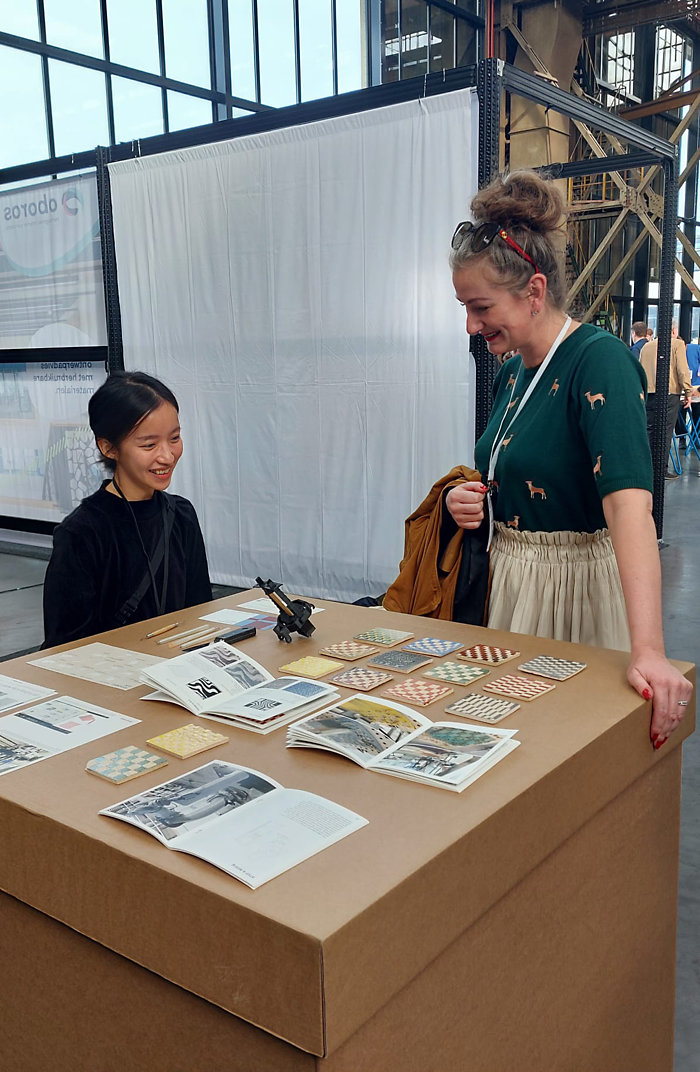 Jong talent zoals Yaya Huang toont innovaties op de beurs. Jong talent zoals Yaya Huang toont innovaties op de beurs